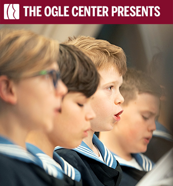 Vienna Boys Choir members singing in uniform with The Ogle Center Presents banner.